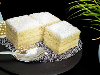 Prăjitură cu cocos pe farfurie neagră elegantă.